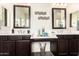 Bathroom featuring double sinks with mirrors and a vanity area between them; decorative vases are displayed at 10452 E Natal Ave, Mesa, AZ 85209