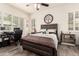 Bedroom features a bed, a ceiling fan, and bright natural light through white shuttered windows at 10452 E Natal Ave, Mesa, AZ 85209