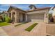Charming stone accented home featuring a 2 car garage and manicured lawn at 10452 E Natal Ave, Mesa, AZ 85209