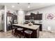 Modern kitchen with dark cabinets, stainless steel appliances, and a large center island with granite countertops at 10452 E Natal Ave, Mesa, AZ 85209
