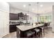 An open concept kitchen with dark cabinets, stainless appliances, a center island, and adjacent dining area at 10452 E Natal Ave, Mesa, AZ 85209