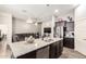 Kitchen island with stainless steel dishwasher and granite countertops, and view of the living room at 10452 E Natal Ave, Mesa, AZ 85209