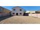 Backyard view of the two-story home with a patio, block wall, and gravel landscaping, offering privacy at 10521 W Toronto Way, Tolleson, AZ 85353