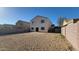 Spacious backyard featuring a neutral-toned stucco exterior, patio, and low-maintenance gravel landscaping, perfect for outdoor living at 10521 W Toronto Way, Tolleson, AZ 85353