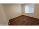 Bedroom with hardwood flooring, bright window, and neutral walls, offering a clean and comfortable space at 10521 W Toronto Way, Tolleson, AZ 85353