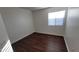 Bedroom with hardwood flooring, a bright window, and neutral walls creating a serene space at 10521 W Toronto Way, Tolleson, AZ 85353