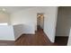 Hallway in a home with wood-look laminate flooring and neutral paint, leading to bedrooms at 10521 W Toronto Way, Tolleson, AZ 85353