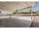 This spacious back patio is covered and features concrete flooring, exposed beams, and hanging lights at 11210 S Bannock St, Phoenix, AZ 85044