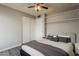 The stylish bedroom boasts wood-look floors, neutral walls, a modern ceiling fan, and a closet with sliding doors at 11210 S Bannock St, Phoenix, AZ 85044