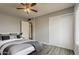 This comfortable bedroom features neutral walls, grey laminate flooring, a ceiling fan, and a spacious closet at 11210 S Bannock St, Phoenix, AZ 85044