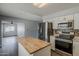 Bright kitchen with stainless steel appliances and an island, connected to a living area at 11210 S Bannock St, Phoenix, AZ 85044