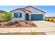 Charming single-story home featuring desert landscaping, a blue garage door, and a covered front entryway at 1123 E Meadowbrook Dr, Casa Grande, AZ 85122