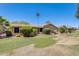 Green backyard with a grassy area, mature trees, and a patio, offering a relaxing outdoor space at 1289 Leisure World --, Mesa, AZ 85206