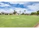 Wide shot of the clubhouse featuring a well-manicured lawn, clock tower, and beautiful desert landscaping at 1289 Leisure World --, Mesa, AZ 85206