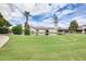 Picturesque community clubhouse with a pond, verdant landscaping, and a view of the clock tower at 1289 Leisure World --, Mesa, AZ 85206