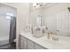 Bright bathroom showcases white cabinets, a large mirror, and a shower-tub combination at 1360 S Camellia Ct, Chandler, AZ 85286