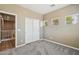 Bright bedroom with gray carpet, a closet with bi-fold doors, and a view of the stairs at 1360 S Camellia Ct, Chandler, AZ 85286