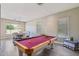 Spacious game room with a pool table, poker table, hardwood floors, and ample natural light at 1360 S Camellia Ct, Chandler, AZ 85286