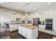 Spacious kitchen with white cabinets, granite countertops, a center island, and stainless steel appliances at 1360 S Camellia Ct, Chandler, AZ 85286