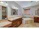 Bathroom features a soaking tub, dual vanities and a framed mirror at 1414 W Coral Reef Dr, Gilbert, AZ 85233