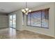 Dining area with a large window overlooking a lake, complemented by a modern chandelier at 1414 W Coral Reef Dr, Gilbert, AZ 85233