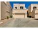 Exterior of townhome featuring a two-car garage, desert landscaping and neutral-colored stucco at 1414 W Coral Reef Dr, Gilbert, AZ 85233