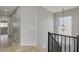 Bright hallway features tile flooring, chandelier and black railing to stairs at 1414 W Coral Reef Dr, Gilbert, AZ 85233