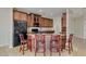 Kitchen island with granite countertop, seating, dark wood cabinets and black appliances at 1414 W Coral Reef Dr, Gilbert, AZ 85233