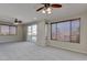 Large living room with carpet and ceiling fans featuring a balcony and large windows at 1414 W Coral Reef Dr, Gilbert, AZ 85233