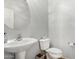 Cozy powder room features a pedestal sink and a round mirror at 14907 N 177Th Ave, Surprise, AZ 85388