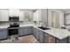 Well-lit kitchen featuring stainless steel appliances, a double sink, and white and gray cabinetry for a modern look at 14907 N 177Th Ave, Surprise, AZ 85388