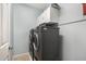 Well-equipped laundry room with gray washer and dryer, white cabinets and tile flooring at 14907 N 177Th Ave, Surprise, AZ 85388