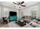 Comfortable living room with a ceiling fan, plush sofa, and bright windows, creating a cozy and inviting atmosphere at 14907 N 177Th Ave, Surprise, AZ 85388
