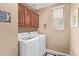 Well-lit laundry room with modern appliances, cabinets, and shelving for efficient laundry care at 15910 W Shangri La Rd, Surprise, AZ 85379