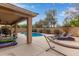 Backyard featuring a covered patio, refreshing pool, hammock, and lounge chairs, perfect for outdoor relaxation at 15910 W Shangri La Rd, Surprise, AZ 85379