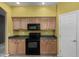 Kitchen featuring wood cabinetry and black appliances at 16527 N 71St Dr, Peoria, AZ 85382