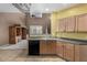 Bright kitchen featuring wood cabinets and a black dishwasher at 16527 N 71St Dr, Peoria, AZ 85382