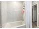 Bathroom featuring marble-like tile, a white tub, and a shower head for a clean and modern design at 16632 W Jenan St, Surprise, AZ 85388