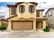 Charming two-story home featuring a two-car garage, tan stucco, and decorative shutters at 16632 W Jenan St, Surprise, AZ 85388