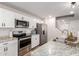 Well-lit kitchen featuring stainless steel appliances, granite countertops and crisp, white cabinetry at 16632 W Jenan St, Surprise, AZ 85388