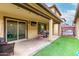 Covered patio with outdoor seating, artificial turf, and sliding doors, perfect for relaxation and entertainment at 16632 W Jenan St, Surprise, AZ 85388