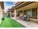Covered patio with outdoor furniture, artificial turf, and playful decor, perfect for relaxation and entertainment at 16632 W Jenan St, Surprise, AZ 85388