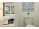 Cozy bathroom featuring a toilet and partial bedroom view with a stylish bed and tasteful decor, creating a serene atmosphere at 16934 W Bronco Trl, Surprise, AZ 85387
