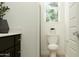 Bright bathroom with a dark vanity, a modern toilet, a window with natural light, and neutral decor at 16934 W Bronco Trl, Surprise, AZ 85387