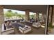 An outdoor seating area with comfortable couches, tables, and a fireplace feature at 16934 W Bronco Trl, Surprise, AZ 85387