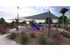 Community playground with shade structure, climbing structures, and seating at 16934 W Bronco Trl, Surprise, AZ 85387