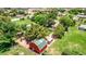Aerial view of rural property featuring a red barn, grassy fields, and mature trees in a tranquil setting at 17730 E Brooks Farm Rd, Gilbert, AZ 85298