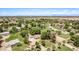 Sprawling community showcasing well-kept homes, mature shade trees, and verdant lawns under a clear blue sky at 17730 E Brooks Farm Rd, Gilbert, AZ 85298
