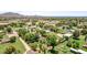 Scenic aerial view of homes with large properties in a green, open area with mountain backdrop at 17730 E Brooks Farm Rd, Gilbert, AZ 85298