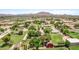 Wide aerial view of a verdant neighborhood with spacious lots and mountain views at 17730 E Brooks Farm Rd, Gilbert, AZ 85298